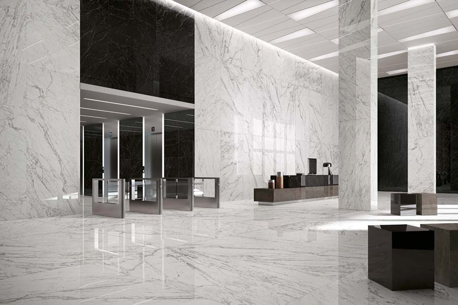 Marvel Pro Statuario Select tile installed on floors and partial walls with Noir St. Laurent installed on walls as well in large office lobby