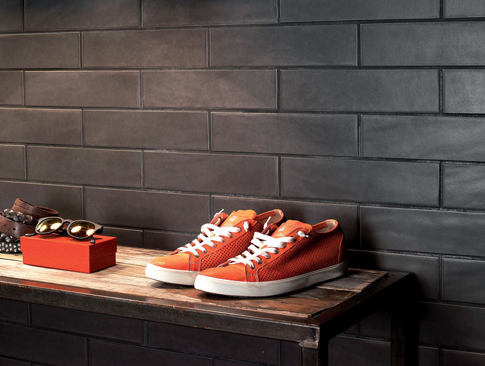Argilla porcelain tile installed on walls with table holding luxury goods.