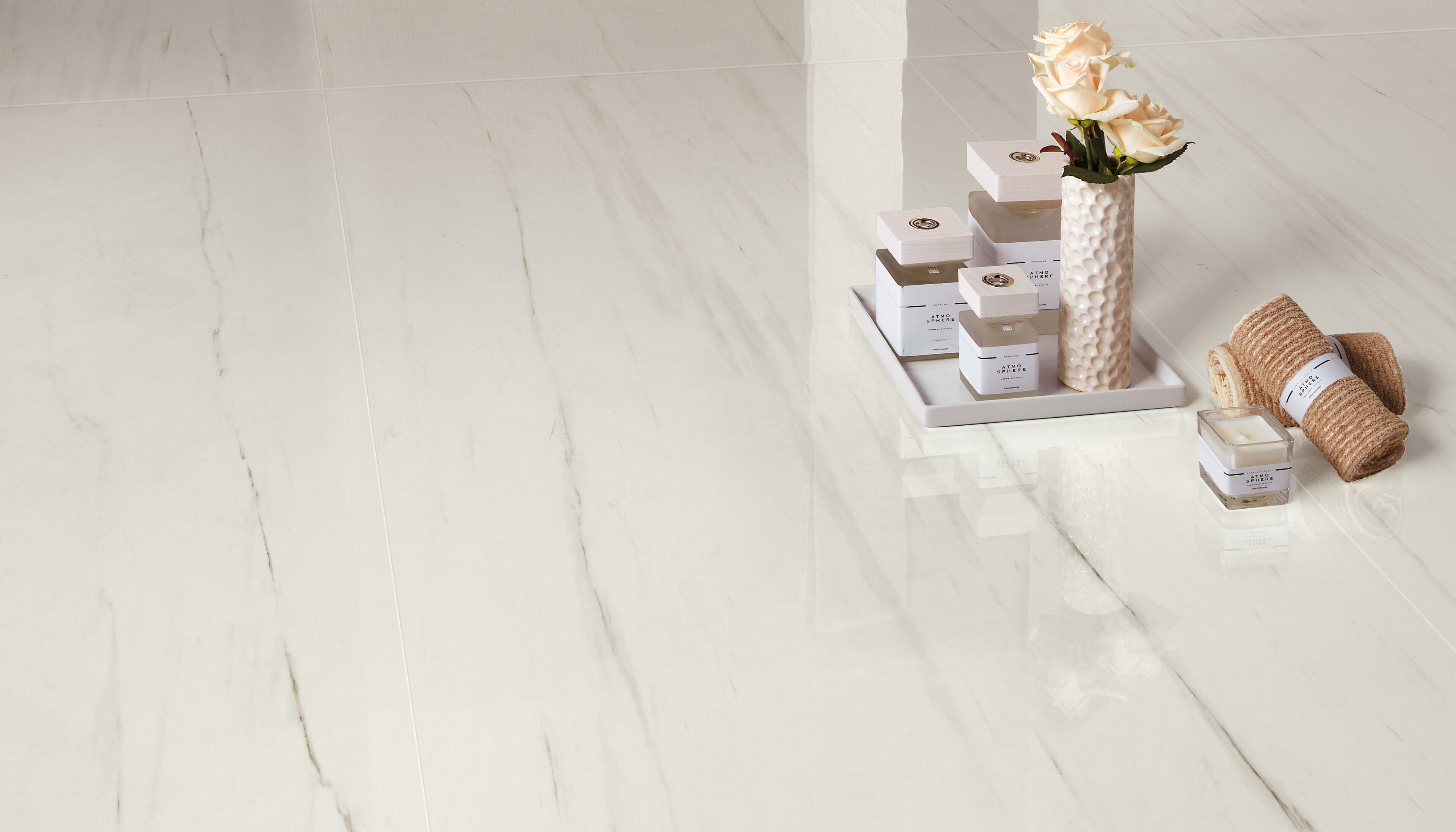 Marvel Stone Bianco Dolomite tile installed on floors with tray of lotions and towles on top