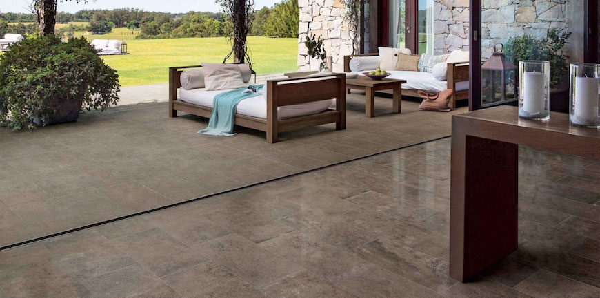 Castlestone porcelain tile in musk featured on the floor of an indoor-outdoor living space.
