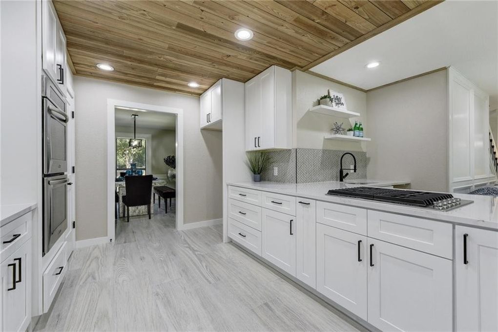 White kitchen with quartz countertops and wood ceilings