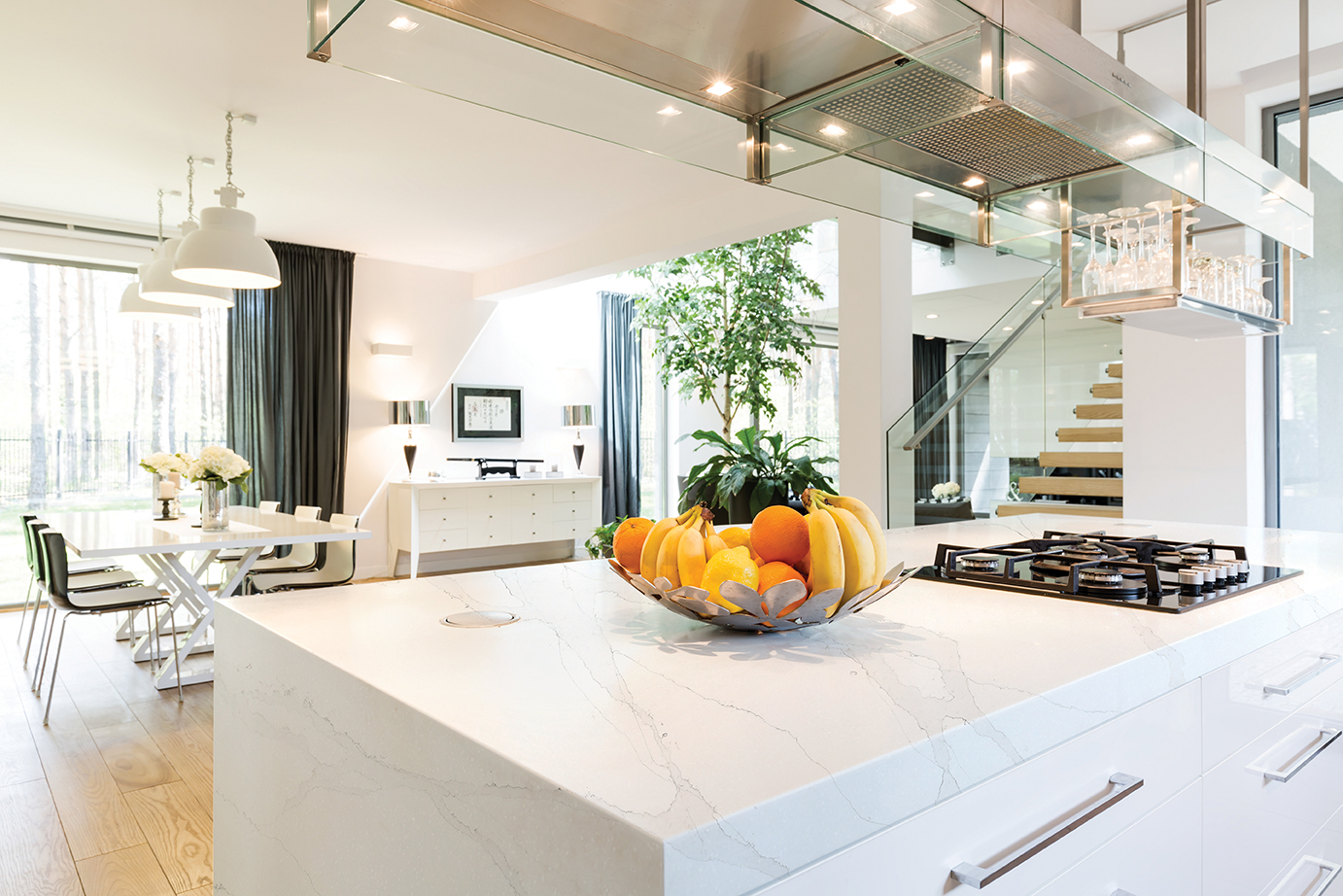 Well-lighted space of open plan kitchen area with kitchen island and with the view of dining room