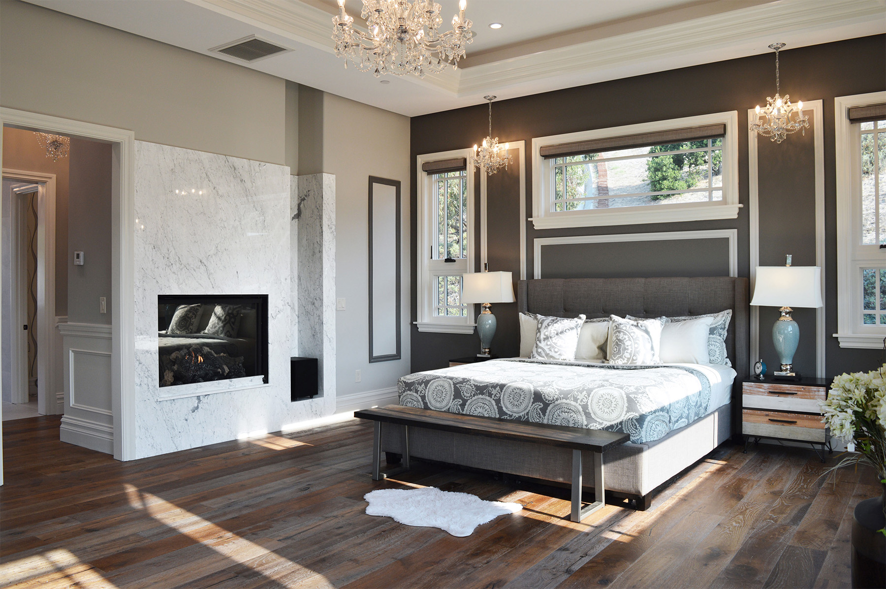 Carrara marble featured in modern bedroom with wood floors and grey walls
