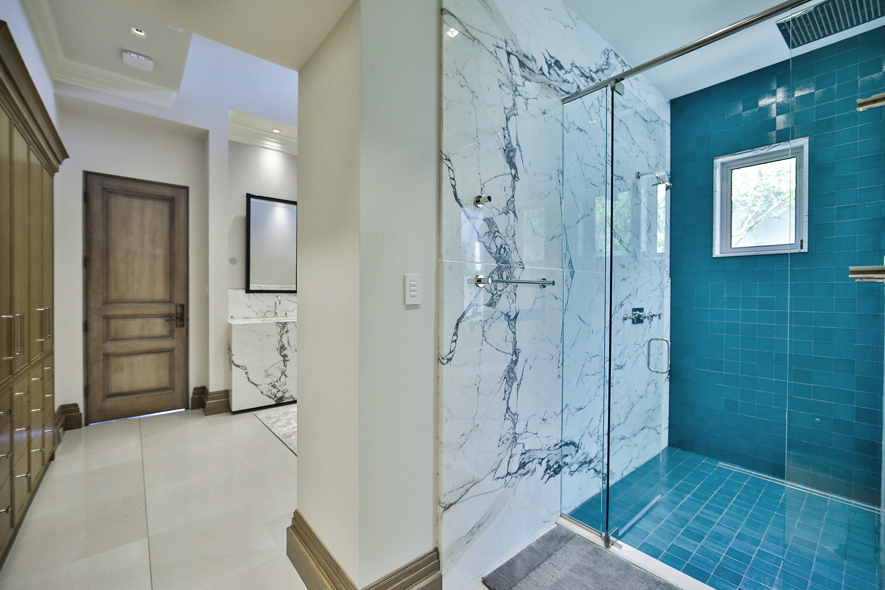 Statuarietto marble installed in shower with blue tiles