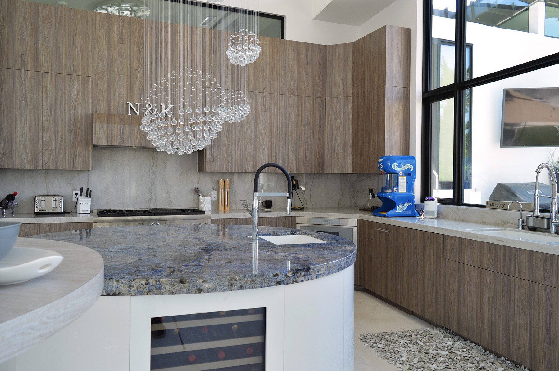 Blue Bahia granite and White Pearl quartzite featured in kitchen with brown cabinets