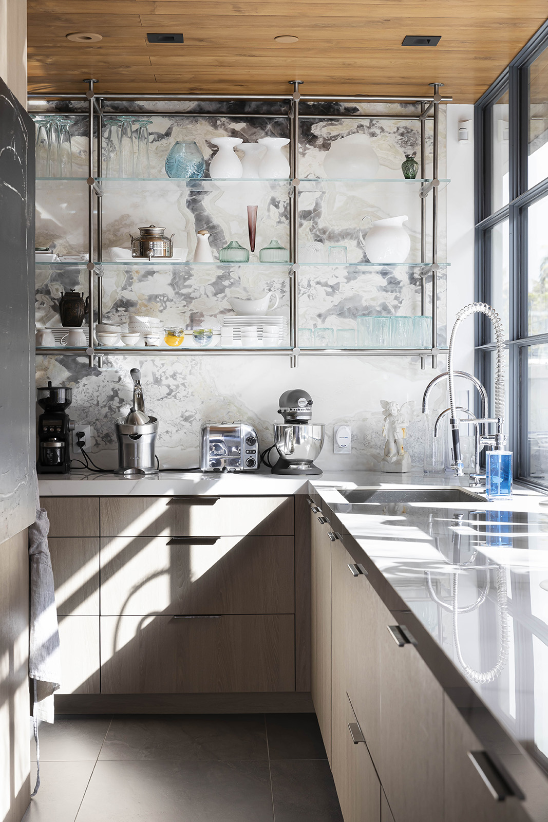 Black Oyster dolomite installed on kitchen wall with glass shelves