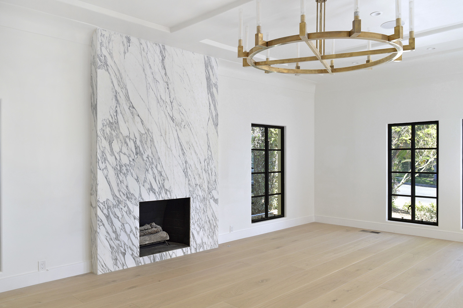 Arabescato Corchia marble fireplace in a living room with wood floors