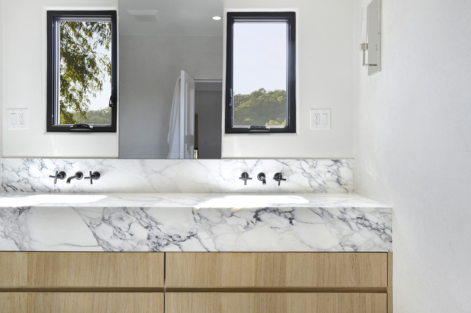 Calacatta Monet marble featured in bathroom with beige cabinets