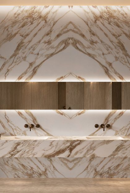 AuthTerra Calacatta Vagli Gold 9105 bookmatched bathroom wall with floating double vanity and backlit mirror